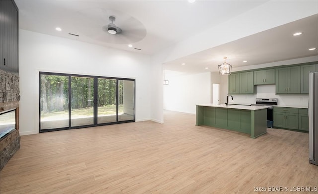 370 Via Appia Dr, Sunrise Beach, MO 65079 - kitchen with green cabinetry, stainless steel appliances, a ceiling fan, light countertops, and light wood-style floors