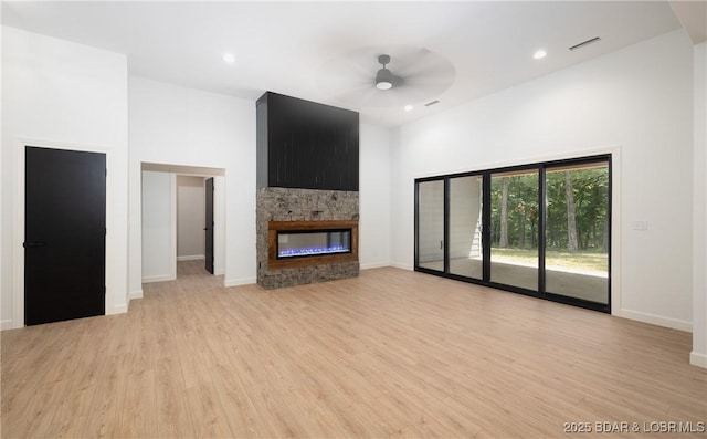 370 Via Appia Dr, Sunrise Beach, MO 65079 - unfurnished living room featuring a ceiling fan, light wood-type flooring, a fireplace, a high ceiling, and recessed lighting