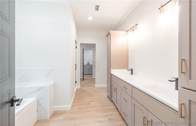 370 Via Appia Dr, Sunrise Beach, MO 65079 - full bathroom with a garden tub, wood finished floors, double vanity, and recessed lighting