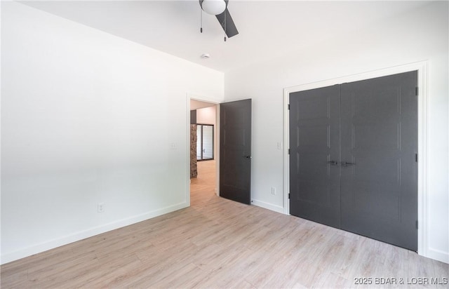 370 Via Appia Dr, Sunrise Beach, MO 65079 - unfurnished bedroom featuring wood finished floors, a closet, and a ceiling fan