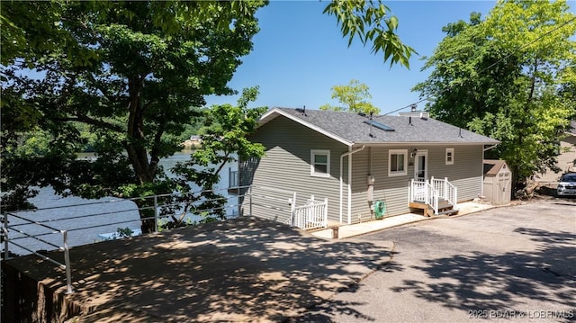 150 Trigger Rd, Linn Creek, MO 65052 - view of front of house featuring a shed, asphalt driveway, and roof with shingles