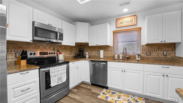 150 Trigger Rd, Linn Creek, MO 65052 - kitchen featuring appliances with stainless steel finishes, light wood-style floors, white cabinets, and recessed lighting