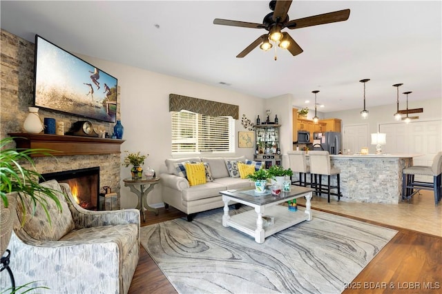 18132 Millstone Cove Rd Unit 334, Gravois Mills, MO 65037 - living room with wood finished floors, a ceiling fan, and a stone fireplace