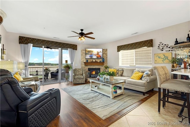 18132 Millstone Cove Rd Unit 334, Gravois Mills, MO 65037 - living area with ceiling fan, a stone fireplace, and wood finished floors