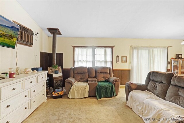 333 Crane Cove Rd, Sunrise Beach, MO 65079 - living area featuring a wood stove, light colored carpet, a wainscoted wall, and wood walls