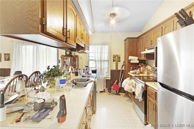 333 Crane Cove Rd, Sunrise Beach, MO 65079 - kitchen with appliances with stainless steel finishes, light countertops, under cabinet range hood, and brown cabinetry