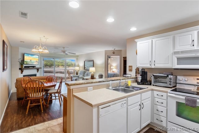 686 Clearwater Dr Unit 2C, Camdenton, MO 65020 - kitchen with white appliances, a peninsula, white cabinetry, light countertops, and recessed lighting