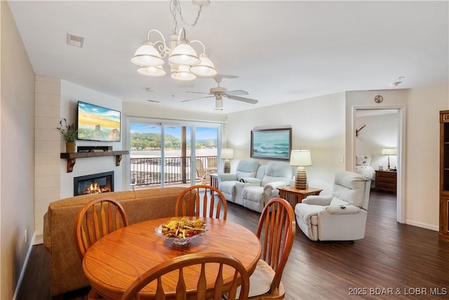 686 Clearwater Dr Unit 2C, Camdenton, MO 65020 - dining room featuring a glass covered fireplace, wood finished floors, a ceiling fan, and a chandelier