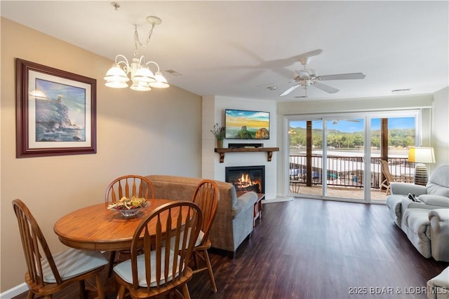 686 Clearwater Dr Unit 2C, Camdenton, MO 65020 - dining room featuring a fireplace, dark wood-type flooring, ceiling fan, and a chandelier
