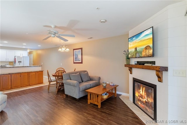 686 Clearwater Dr Unit 2C, Camdenton, MO 65020 - living room featuring a glass covered fireplace, dark wood-style flooring, ceiling fan, and recessed lighting