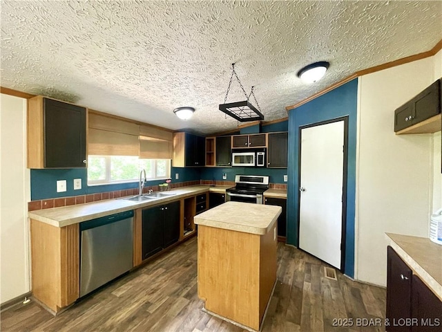 4712 Camden Line Rd, Lebanon, MO 65536 - kitchen with stainless steel appliances, light countertops, dark wood-type flooring, crown molding, and a kitchen island