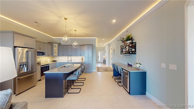1065 Topsider Ln Unit 505, Osage Beach, MO 65065 - kitchen with appliances with stainless steel finishes, gray cabinets, a breakfast bar, decorative backsplash, and light stone counters