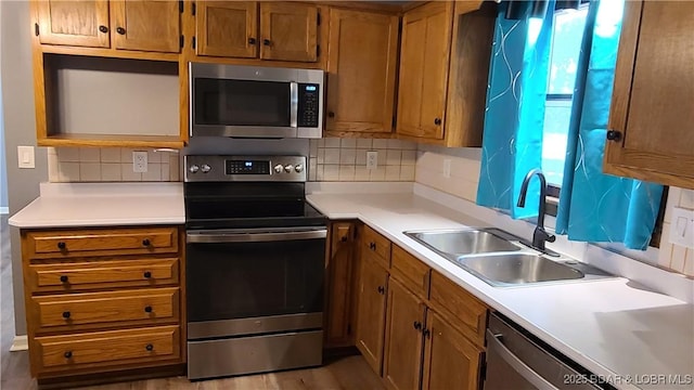 508 Hunter St N, Versailles, MO 65084 - kitchen with appliances with stainless steel finishes, tasteful backsplash, brown cabinetry, and light countertops