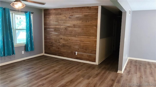 508 Hunter St N, Versailles, MO 65084 - unfurnished room featuring wood walls, wood finished floors, and a ceiling fan
