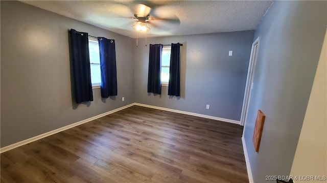 508 Hunter St N, Versailles, MO 65084 - spare room with a textured ceiling, dark wood finished floors, and a ceiling fan