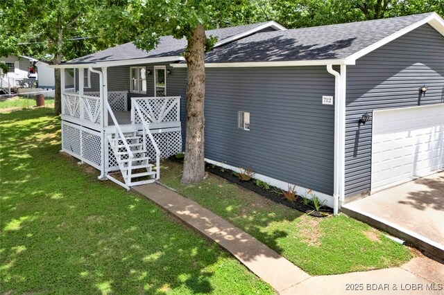 712 Passover Rd, Osage Beach, MO 65065 - view of front of property with a porch, a front lawn, a shingled roof, and a garage
