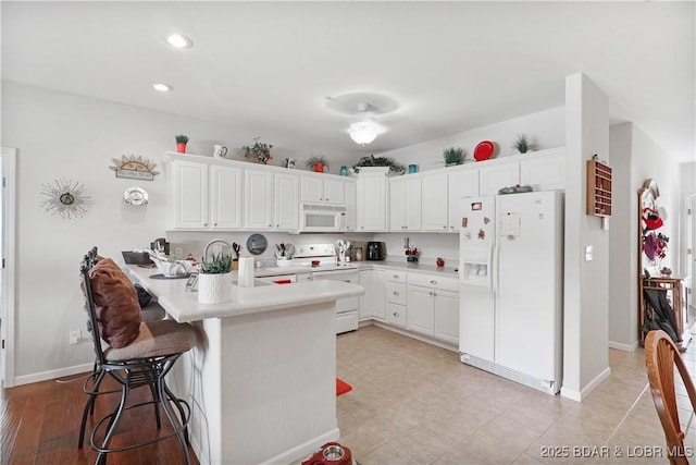 562 Hyd A Way Rd Unit 3F, Camdenton, MO 65020 - kitchen with white appliances, a peninsula, light countertops, white cabinetry, and recessed lighting