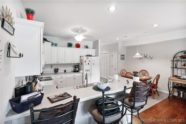 562 Hyd A Way Rd Unit 3F, Camdenton, MO 65020 - kitchen featuring white fridge with ice dispenser, a breakfast bar, a peninsula, light countertops, and white cabinets