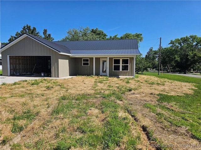 501 W 12th St, Eldon, MO 65026 - view of front of property with an attached garage, a metal roof, driveway, and covered porch