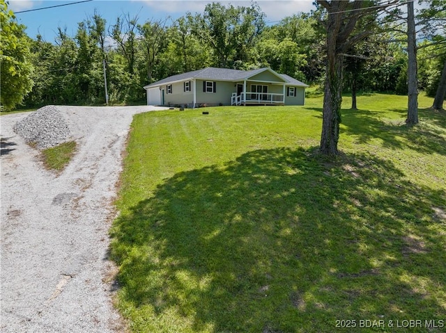 326 State Rd W, Macks Creek, MO 65786 - single story home featuring driveway, a front yard, a garage, and a view of trees