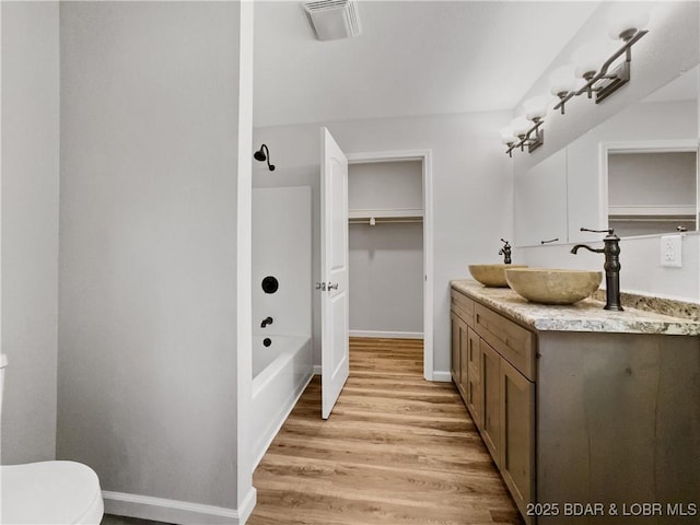 326 State Rd W, Macks Creek, MO 65786 - bathroom featuring vanity, wood finished floors, and shower / bathtub combination