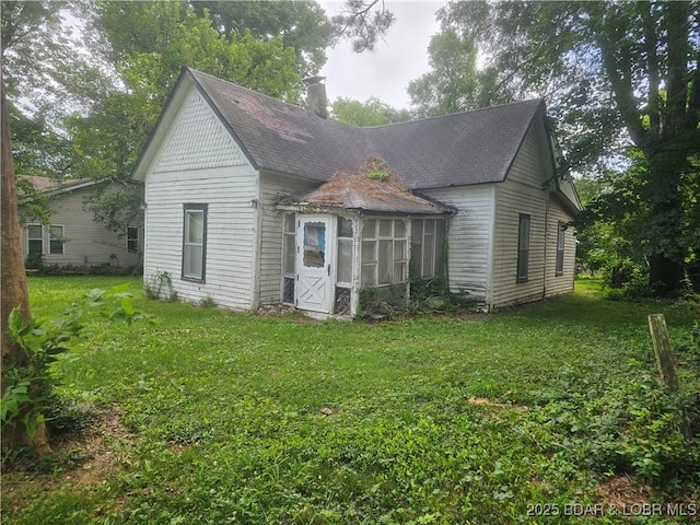 412 Maple St, Eldon, MO 65026 - back of house with a sunroom, a yard, a shingled roof, and a chimney