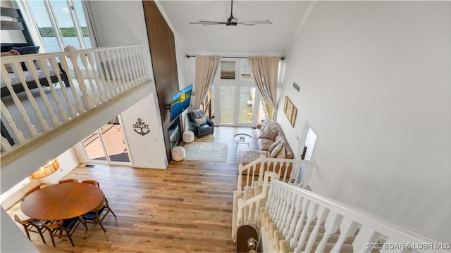 2268 Breezy Acres Rd, Osage Beach, MO 65065 - stairs featuring crown molding, healthy amount of natural light, wood finished floors, a towering ceiling, and ceiling fan