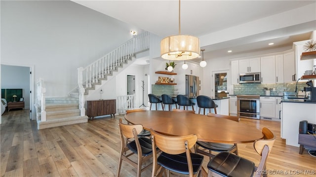 2268 Breezy Acres Rd, Osage Beach, MO 65065 - dining room featuring stairway, light wood-type flooring, and recessed lighting