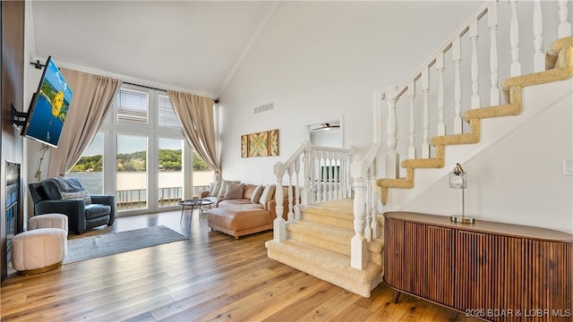 2268 Breezy Acres Rd, Osage Beach, MO 65065 - living area featuring high vaulted ceiling, stairs, hardwood / wood-style flooring, a ceiling fan, and ornamental molding