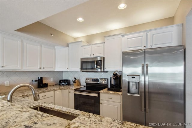 68 Lighthouse Rd Unit 906, Lake Ozark, MO 65049 - kitchen featuring appliances with stainless steel finishes, white cabinetry, light stone counters, tasteful backsplash, and recessed lighting