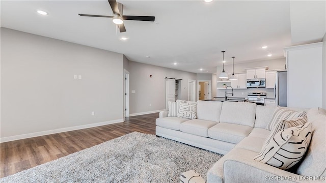 104 Sierra Bay Dr Unit 1B, Camdenton, MO 65020 - living area with wood finished floors, a ceiling fan, a barn door, and recessed lighting
