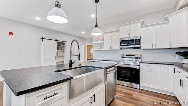 104 Sierra Bay Dr Unit 1B, Camdenton, MO 65020 - kitchen with appliances with stainless steel finishes, open shelves, a barn door, hanging light fixtures, and recessed lighting