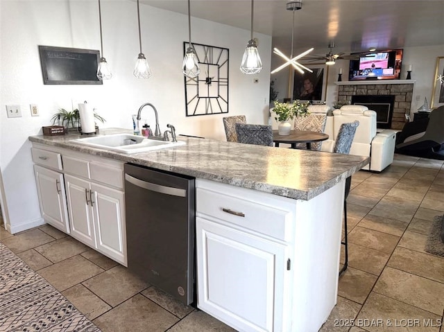 63 Rock Dove Ln, Camdenton, MO 65020 - kitchen featuring stainless steel dishwasher, a fireplace, white cabinets, ceiling fan, and pendant lighting
