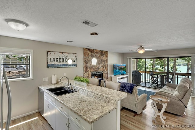 2500 Bay Point Dr Unit 331, Osage Beach, MO 65065 - kitchen with a peninsula, open floor plan, a textured ceiling, a fireplace, and ceiling fan