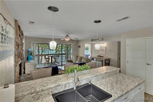 2500 Bay Point Dr Unit 331, Osage Beach, MO 65065 - kitchen featuring a ceiling fan, open floor plan, pendant lighting, and light stone countertops