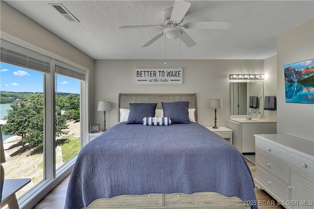 2500 Bay Point Dr Unit 331, Osage Beach, MO 65065 - bedroom with wood finished floors, connected bathroom, and a ceiling fan