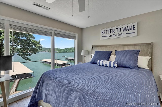 2500 Bay Point Dr Unit 331, Osage Beach, MO 65065 - bedroom with wood finished floors, a water view, access to outside, ceiling fan, and a textured ceiling