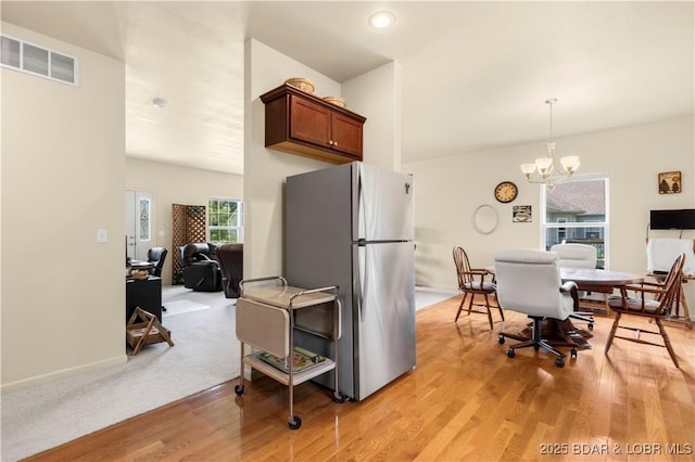 396 Elm Tree Ln, Camdenton, MO 65020 - kitchen featuring freestanding refrigerator, a chandelier, light wood-style floors, and hanging light fixtures