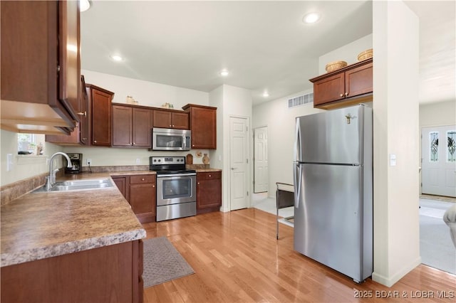 396 Elm Tree Ln, Camdenton, MO 65020 - kitchen with appliances with stainless steel finishes, light wood-style flooring, recessed lighting, and light countertops