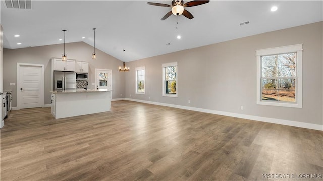 60 Lady Bug Ln, Camdenton, MO 65020 - unfurnished living room featuring a ceiling fan, plenty of natural light, a chandelier, light wood-style flooring, and recessed lighting