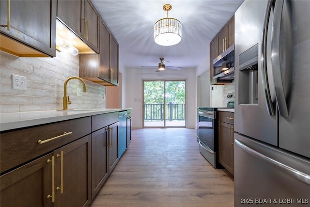 1408 Dogwood Ln, Osage Beach, MO 65065 - kitchen with stainless steel appliances, decorative backsplash, light countertops, light wood finished floors, and a ceiling fan