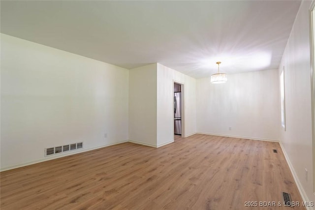 1408 Dogwood Ln, Osage Beach, MO 65065 - empty room featuring light wood-style flooring and a chandelier