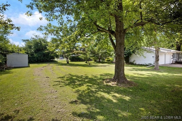 901 Larkin Dr, Eldon, MO 65026 - view of green lawn with an attached garage and an outbuilding