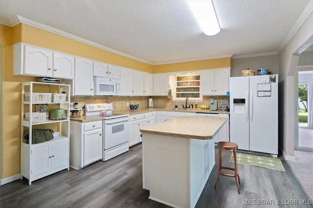 901 Larkin Dr, Eldon, MO 65026 - kitchen with white appliances, dark wood-style flooring, white cabinetry, a center island, and tasteful backsplash