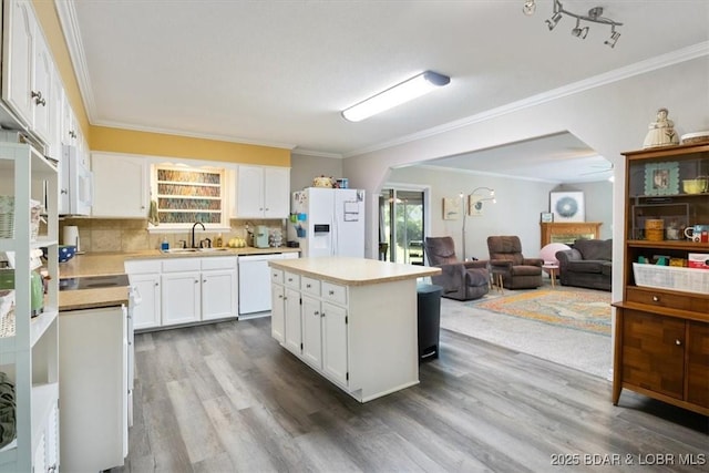 901 Larkin Dr, Eldon, MO 65026 - kitchen with white appliances, wood finished floors, light countertops, crown molding, and a center island
