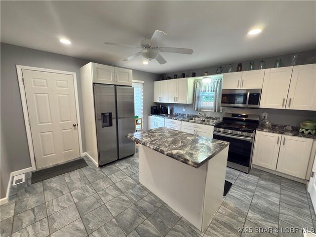 435 Main St, Newburg, MO 65550 - kitchen with appliances with stainless steel finishes, a ceiling fan, white cabinets, recessed lighting, and a kitchen island