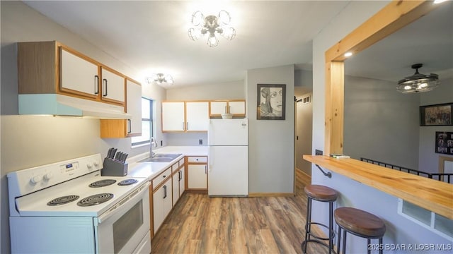 195 Jamie Dr, Camdenton, MO 65020 - kitchen with white appliances, under cabinet range hood, a kitchen bar, light wood finished floors, and vaulted ceiling