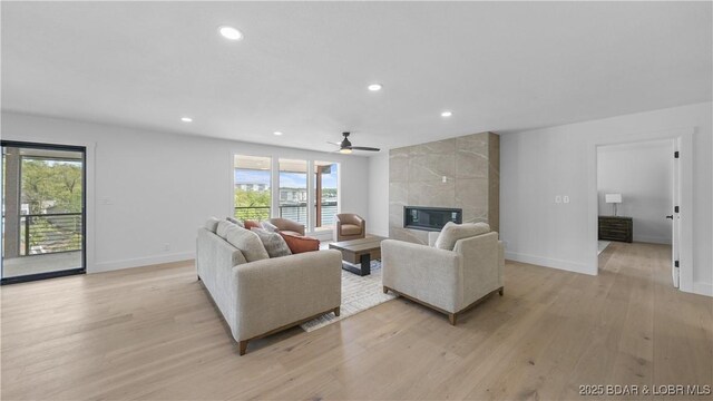 4452 Hamrock Ln, Osage Beach, MO 65065 - living room featuring healthy amount of natural light, light wood-type flooring, a ceiling fan, a fireplace, and recessed lighting