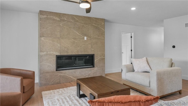 4452 Hamrock Ln, Osage Beach, MO 65065 - living area with ceiling fan, a tiled fireplace, wood finished floors, and recessed lighting