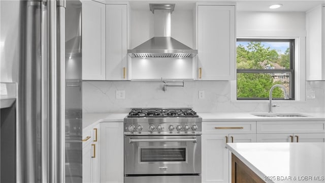 4452 Hamrock Ln, Osage Beach, MO 65065 - kitchen featuring appliances with stainless steel finishes, wall chimney exhaust hood, white cabinetry, and backsplash